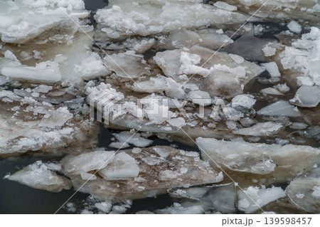 Ice Floes and Broken River Ice Floating on Dark Water in Late Winter Morning 139598457