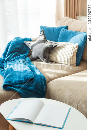 Festive Living Room with Cushions, Blue Blanket, and Open Book Festive Living Room with Cushions, Blue Blanket, and Open Book 139598729