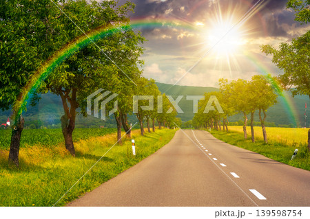 sunset over deciduous trees along the country road in to mountains. beautiful summer landscape of a slovakia countryside. beautiful travel background. journey through europe. weather with rainbow 139598754