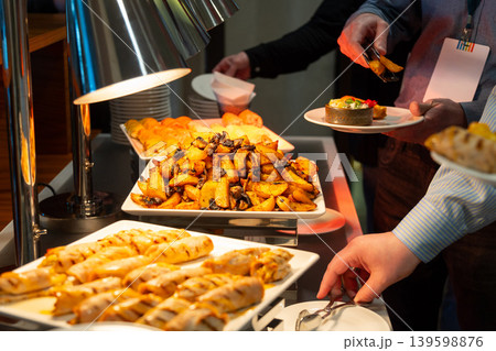 Guest serving roasted potato with mushroom and salad 139598876