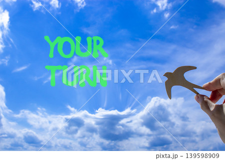 Your turn words symbol. Concept words Your turn on beautiful blue sky. Beautiful blue sky background. Businessman hand. Wooden bird. Business your turn motivational support concept. Copy space. Your turn words symbol. Concept words Your turn on beautiful blue sky. Beautiful blue sky background. Businessman hand. Wooden bird. Business your turn motivational support concept. Copy space. 139598909
