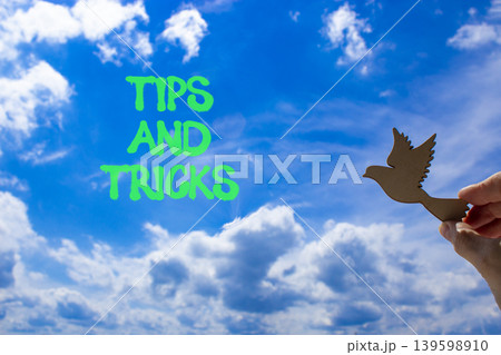 Tips and tricks words symbol. Concept words Tips and tricks on beautiful blue sky. Beautiful blue sky background. Businessman hand. Business tips and tricks motivational support concept. Copy space. 139598910