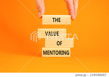 The value of mentoring words symbol. Concept words The value of mentoring on beautiful wooden blocks. Beautiful orange background. Businessman hand. Business the value of mentoring concept. Copy space 139599097