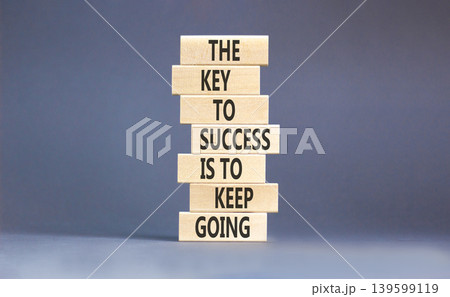 Success and keep going symbol. Concept words The key to success is to keep going on beautiful wooden blocks. Beautiful grey paper background. Business success and keep going concept. Copy space. Success and keep going symbol. Concept words The key to success is to keep going on beautiful wooden blocks. Beautiful grey paper background. Business success and keep going concept. Copy space. 139599119