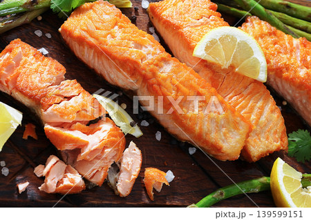 fried salmon with asparagus and lemon on a board fried salmon with asparagus and lemon on a board 139599151