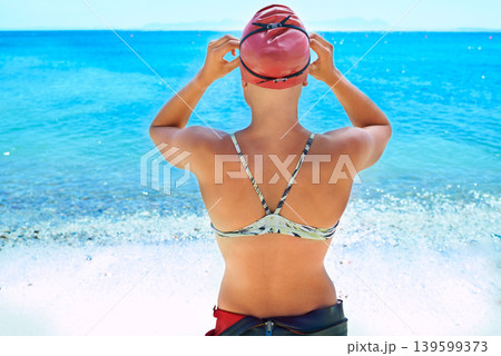 Swimmer, back and woman at ocean outdoor in summer for exercise, water training or workout. Sea, sport athlete cap and rear view of person in nature for fitness, health or triathlon at the beach Swimmer, back and woman at ocean outdoor in summer for exercise, water training or workout. Sea, sport athlete cap and rear view of person in nature for fitness, health or triathlon at the beach 139599373