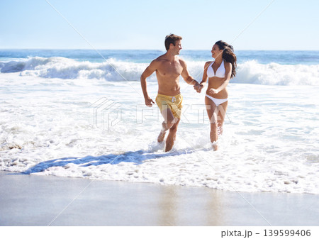 Holding hands, waves and happy couple running on beach for holiday adventure together on tropical island with care. Love, man and woman on ocean vacation with fun, romance and smile on travel in Bali Holding hands, waves and happy couple running on beach for holiday adventure together on tropical island with care. Love, man and woman on ocean vacation with fun, romance and smile on travel in Bali 139599406