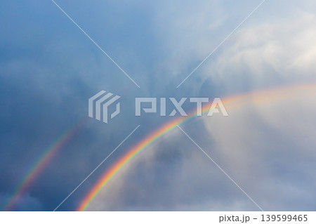 A vibrant double rainbow arcs across a moody blue sky with soft clouds A vibrant double rainbow arcs across a moody blue sky with soft clouds 139599465