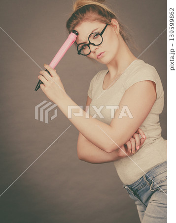 Woman holding big oversized pencil thinking about something 139599862