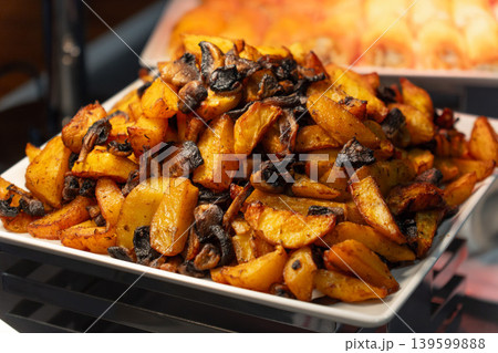 Close-up of delicious roasted potato wedges with mushrooms Close-up of delicious roasted potato wedges with mushrooms 139599888
