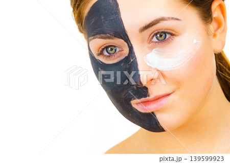 Girl black mask on half face apply white mud 139599923