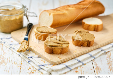 Natural gourmet liver pate spread on a white wooden table, selective focus. Natural gourmet liver pate spread on a white wooden table, selective focus. 139600007