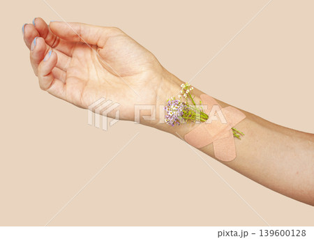 Medical Plaster with flowers on hand. Hand with a medical patch. Medical Plaster with flowers on hand. Hand with a medical patch. 139600128