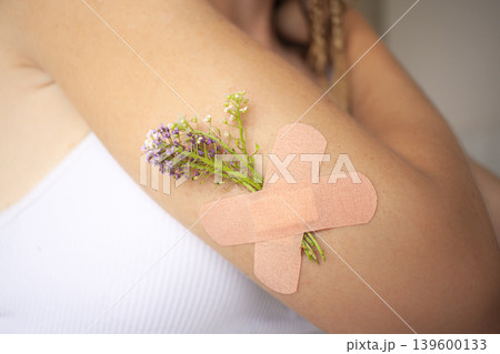Medical Plaster with flowers on hand. Arm with a medical patch. Medical Plaster with flowers on hand. Arm with a medical patch. 139600133