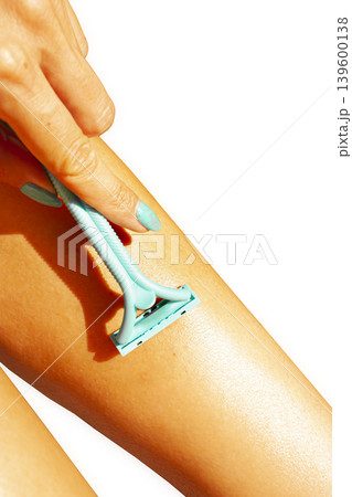 Shaving legs with blue razor on white background. 139600138