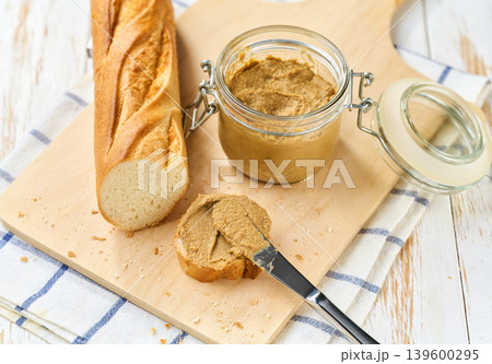cut baguette with liver pate on a white wooden table. 139600295