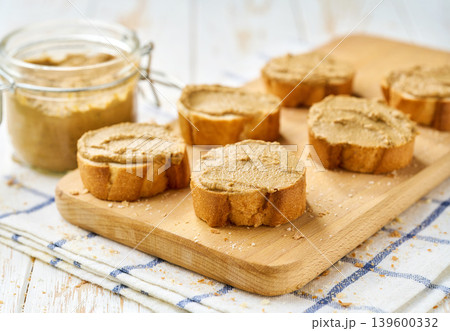 cut baguette with beef liver pate on a white wooden table. 139600332