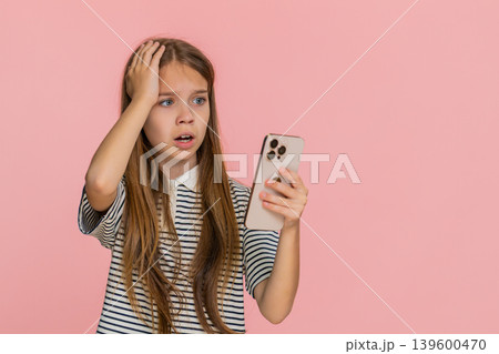 Child girl kid sadly playing mobile online game on smartphone disappointed by lottery game defeat 139600470
