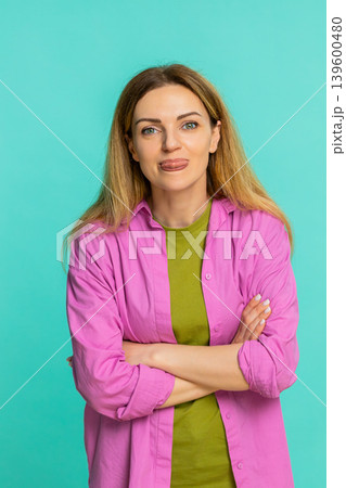 Woman sticking out tongue teasing with playful expression showing fun joke or mild mocking gesture Woman sticking out tongue teasing with playful expression showing fun joke or mild mocking gesture 139600480