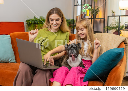 Mother daughter dog win game on laptop get positive test result celebrate good news smile together 139600529