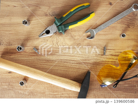 Working tools on wooden background. glasses, pliers, hammer, screwdriver. construction, repair concept Working tools on wooden background. glasses, pliers, hammer, screwdriver. construction, repair concept 139600586