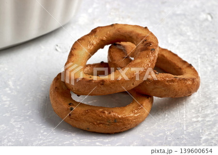 Three salted pretzels with poppy seeds on a stone gray table. Three salted pretzels with poppy seeds on a stone gray table. 139600654