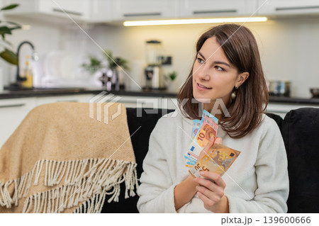 Woman counts euro money cash celebrates high salary and savings plans invest and dream purchase 139600666
