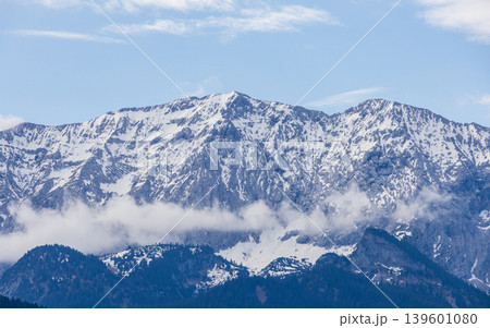 Snow capped Bavarian Alps mountain range with soft clouds in spring sky Snow capped Bavarian Alps mountain range with soft clouds in spring sky 139601080