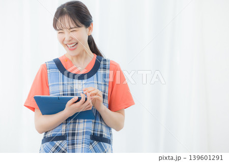 タブレットを持つエプロンの女性 139601291