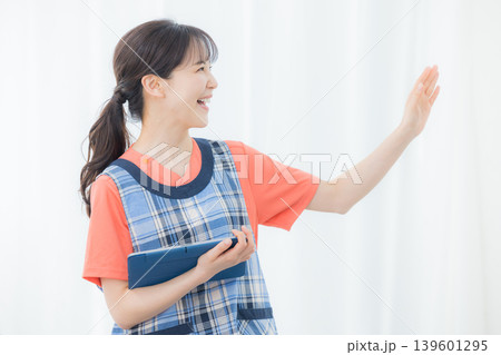 タブレットを持つエプロンの女性 139601295