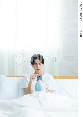 ベッドでスマホを見る男性 139601319