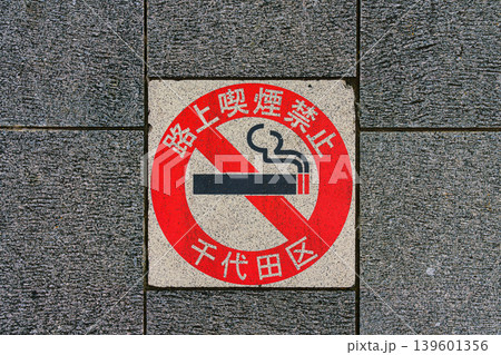 Tokyo, Japan - Oct 1 2024, A close-up view of a no smoking sign with Japanese writing pasted onto a brick sidewalk, Tokyo, Japan  139601356