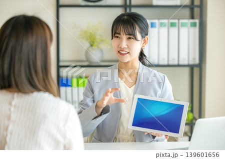 タブレットを持って提案するビジネスウーマン 139601656