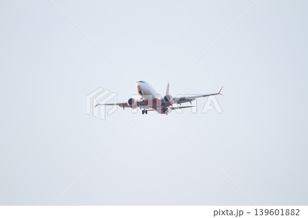 Passenger aircraft with extended landing gear flying through a pale evening sky during final approach for aviation and travel concepts. Passenger aircraft with extended landing gear flying through a pale evening sky during final approach for aviation and travel concepts. 139601882