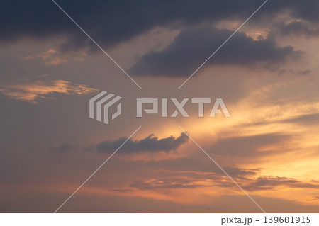Moody storm clouds drifting across a radiant sunset sky with warm golden light and layered atmospheric textures in a peaceful evening scene. Moody storm clouds drifting across a radiant sunset sky with warm golden light and layered atmospheric textures in a peaceful evening scene. 139601915