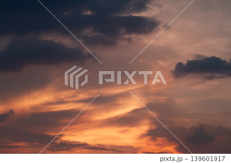 Deep dramatic clouds contrasting with glowing sunset colors and soft atmospheric light creating a striking natural evening sky background. Deep dramatic clouds contrasting with glowing sunset colors and soft atmospheric light creating a striking natural evening sky background. 139601917