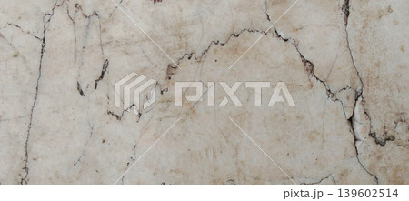 The texture of an old concrete wall with natural cracks and a dull, pale cream colored surface. 139602514