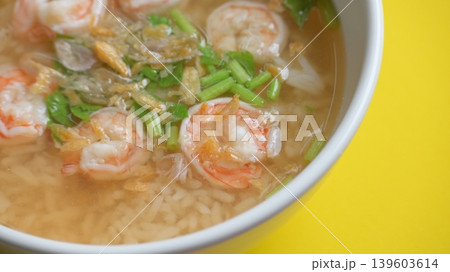 rice soup with shrimp in white bowl on yellow background rice soup with shrimp in white bowl on yellow background 139603614