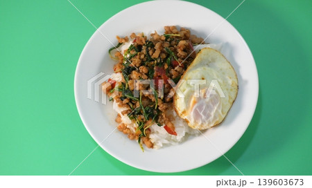 stir fried pork with holy basil on top with fried egg on cooked rice stir fried pork with holy basil on top with fried egg on cooked rice 139603673