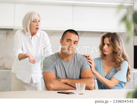 Elderly woman quarrels with couple in kitchen 139604545