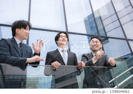 屋外のビル前でポジティブ前向き上司、若手の部下を見守るなど3人チームのイメージ 139604662