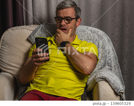 Freelancer checking bad news on mobile phone at night Freelancer checking bad news on mobile phone at night 139605329