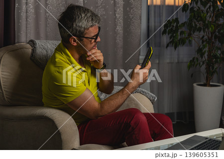Stressed remote worker reading messages on smartphone Stressed remote worker reading messages on smartphone 139605351