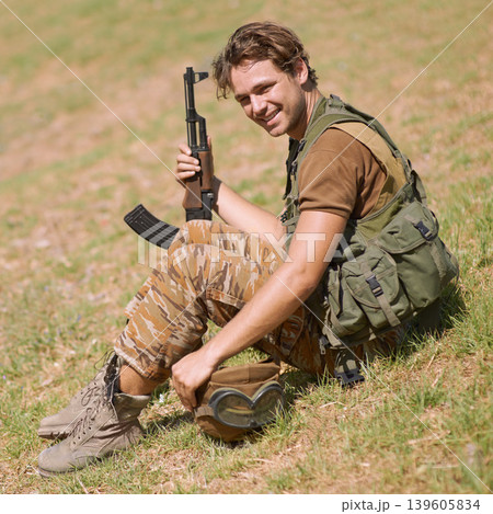 Military, smile and nature with man in and gun for war, conflict and patriotism. Army, surveillance and security with young person and rifle training on grass for soldier, battlefield and veteran 139605834