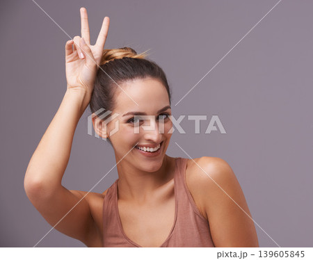 Portrait of happy woman, peace sign or beauty for skincare dermatology results for healthy glow. Spa, hand gesture or natural model with smile, confidence or wellness in studio on purple background 139605845