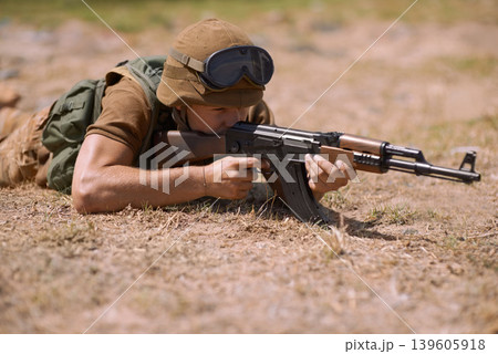 Military, sniper and shooting with man and gun in nature for war, conflict and patriotism. Army, surveillance and security with person and aim with rifle training for soldier, battlefield and veteran 139605918