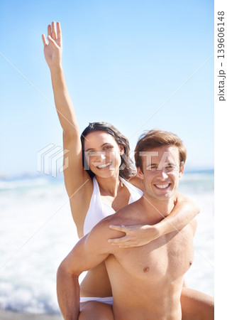 Portrait, energy and piggyback with couple on beach together for holiday, vacation or romantic getaway. Smile, travel or love with happy young man and woman by ocean or sea for coastal adventure 139606148