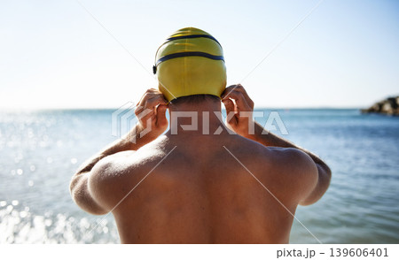 Sports, ocean and back of man for swimming exercise, workout or training in beach, nature or water. Back, swimwear cap and athlete ready to start challenge, fitness contest or practice for triathlon Sports, ocean and back of man for swimming exercise, workout or training in beach, nature or water. Back, swimwear cap and athlete ready to start challenge, fitness contest or practice for triathlon 139606401