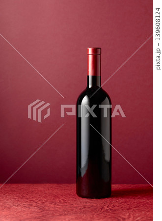 Bottle of red wine on a red background. 139608124