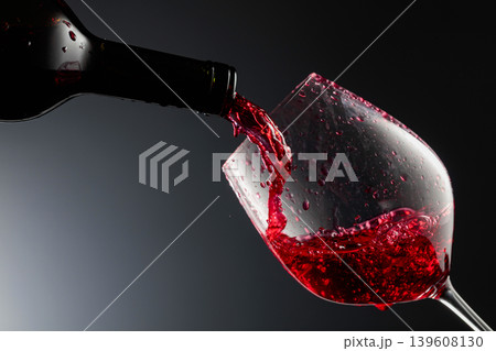 Red wine is poured from a bottle into a glass. Red wine is poured from a bottle into a glass. 139608130